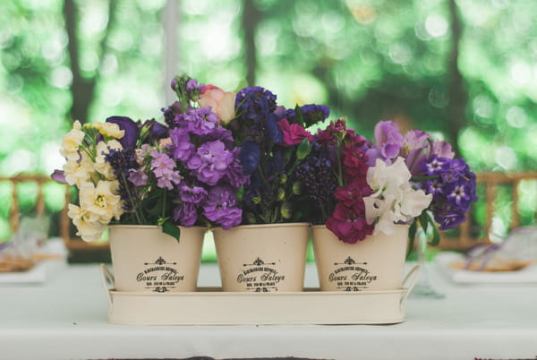 Purple flowers in pots on wedding table