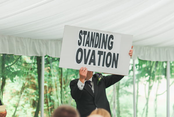 Best man holding up standing ovation sign