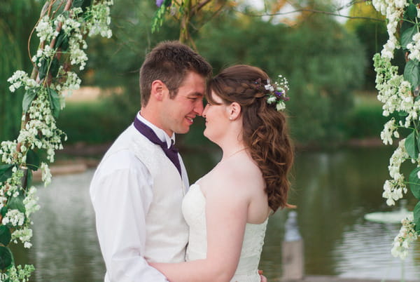 Bride and groom by lake at Narborough Hall Gardens