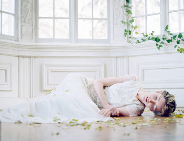 Bride laying on floor surrounded by leaves