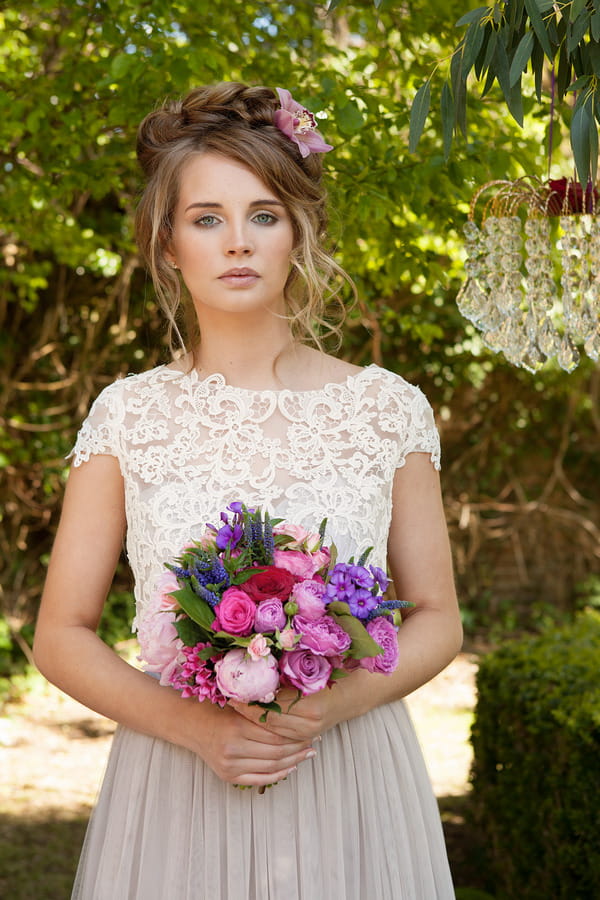 Bride with lace detail wedding dress holding bridal bouquet