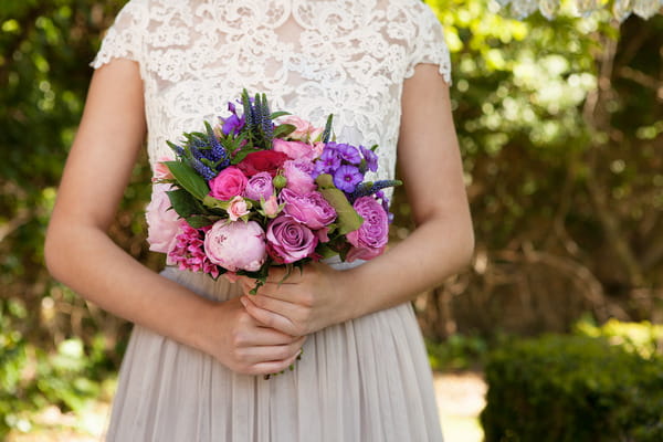 Bride holding pink and purple wedding bouquet