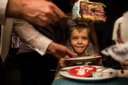 Young looking excitedly at slice of wedding cake - Picture by Steven Herrschaft Photography