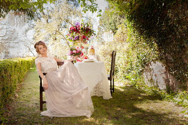 Bride sitting back in chair in garden of Tros Yr Afon