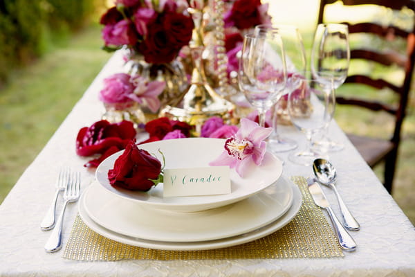 Plate and charger with rose on styled wedding table