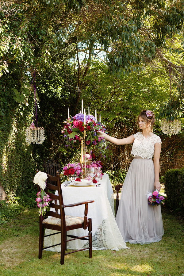 Bride standing next to long styled wedding table