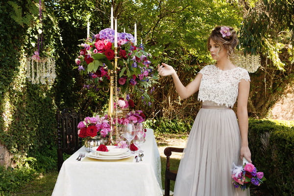 Bride next to styled wedding table in garden at Tros Yr Afon