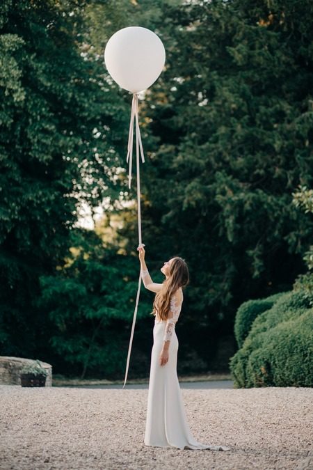 Bride holding long ribbon on white balloon - Picture by M&J Photography