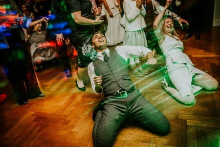 Groom dancing on his knees on wedding dance floor - Picture by Dan Ward Photography