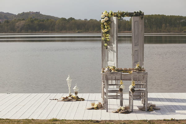 Table with spring flowers on jetty by lake in Italy
