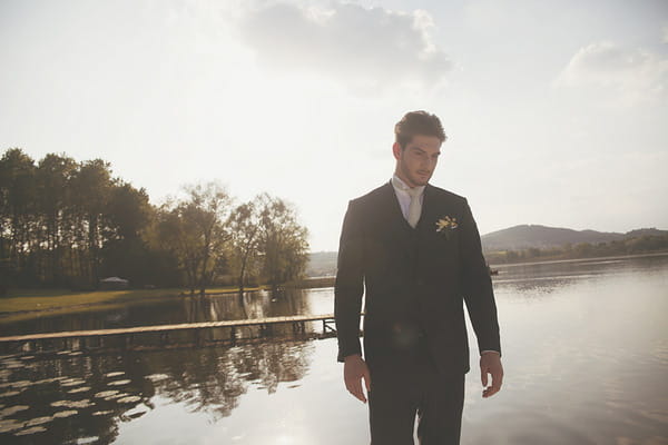 Groom standing by Lake of Candia in Italy