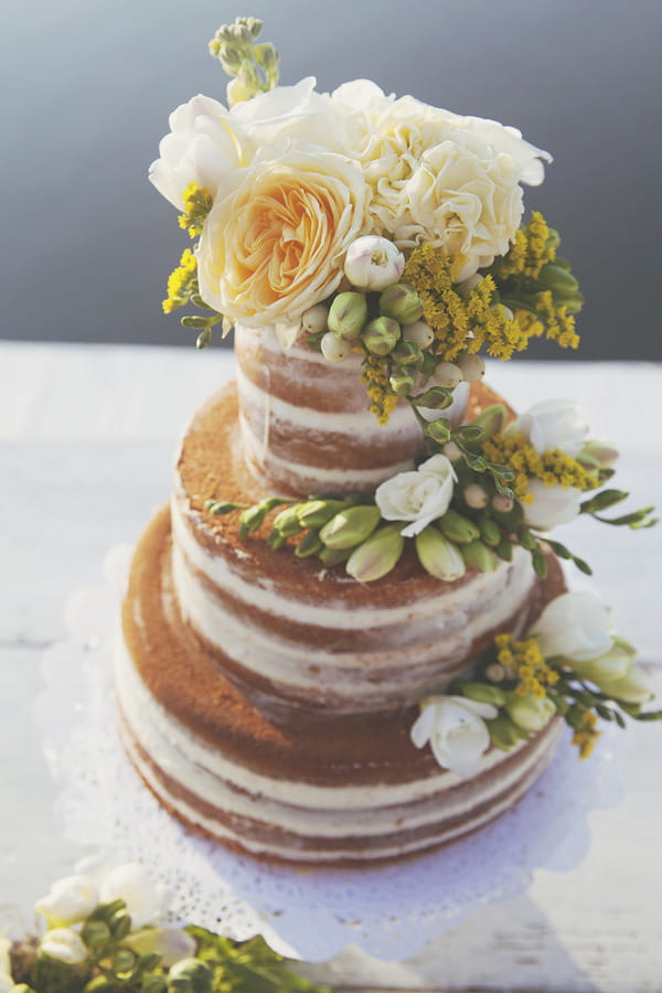 Naked wedding cake with yellow flowers