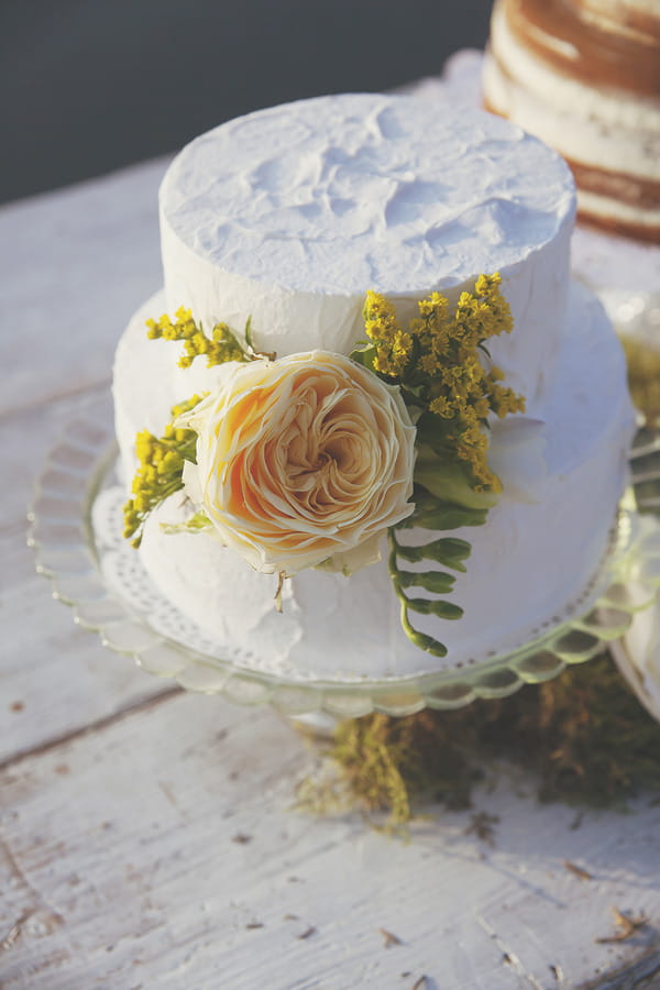 White iced wedding cake with yellow flowers