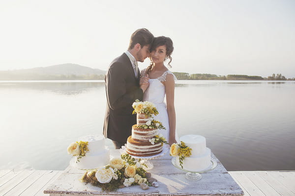 Bride and groom standing by wedding cake table