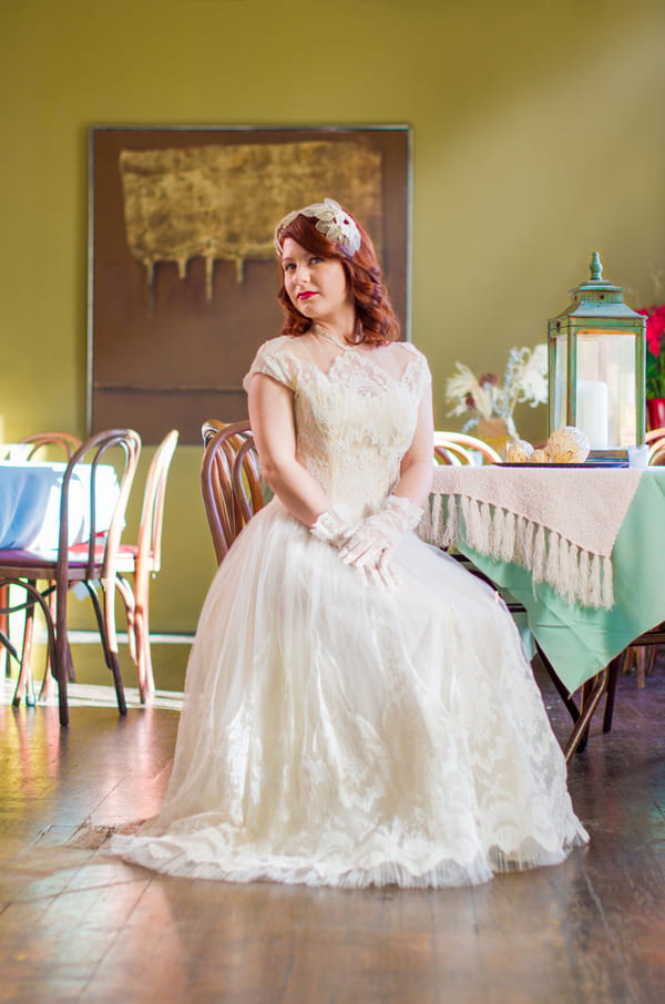 Bride wearing vintage wedding dress sitting on chair