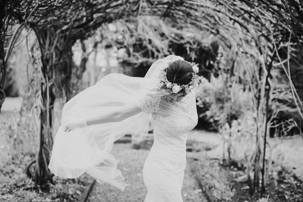 Bride with flower crown and flowing veil looking down - Picture by Samantha Jane Photography