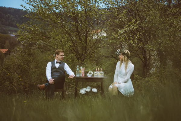 Bride and groom sitting at table in Slovenian countryside