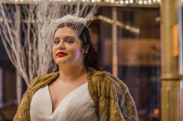 Bride wearing fur shrug and birdcage veil