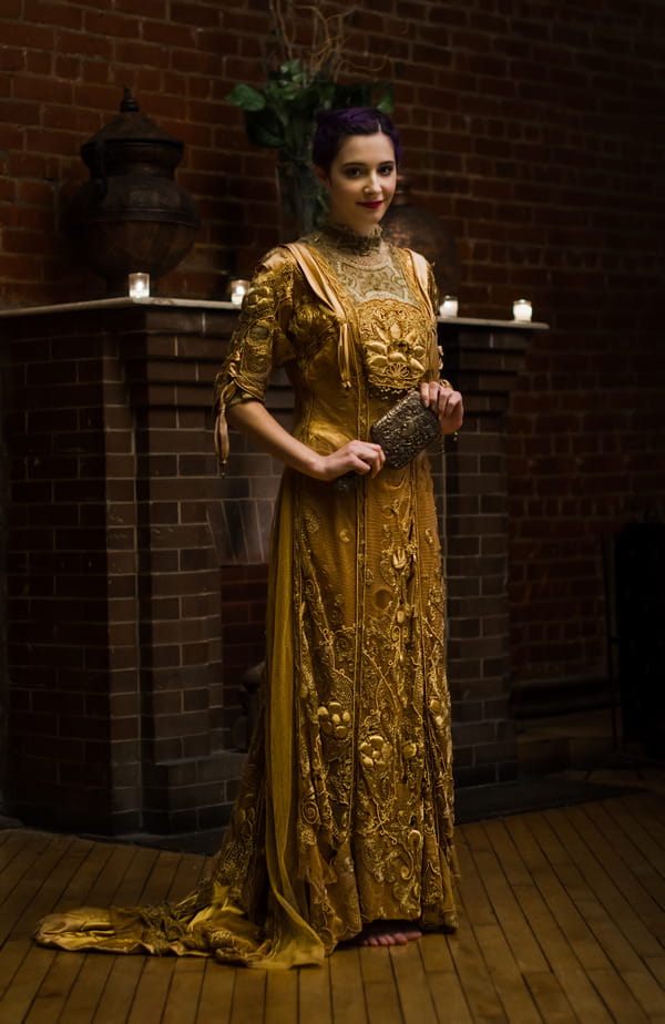 Bride in gold vintage wedding dress holding mirror