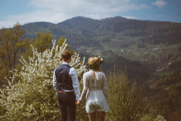 Bride and groom looking at Slovenian countryside