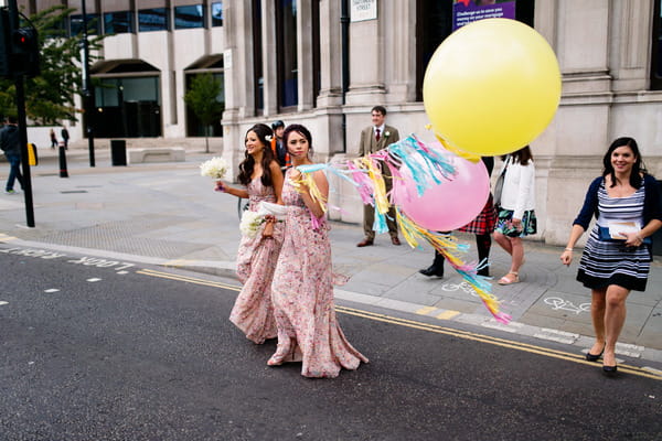 Bridesmaids crossing the road with balloons