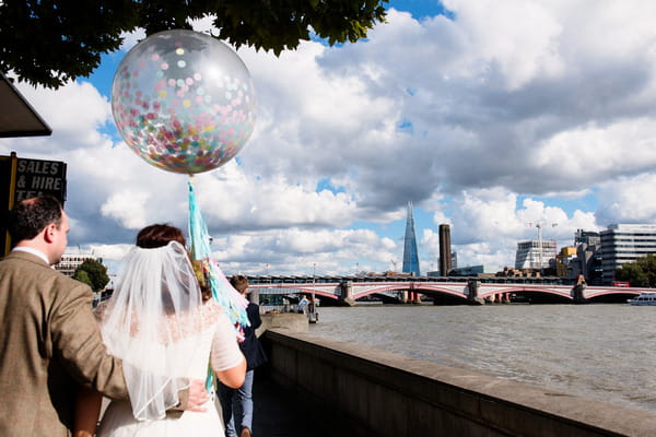 Bride and groom walking along River Thames in London