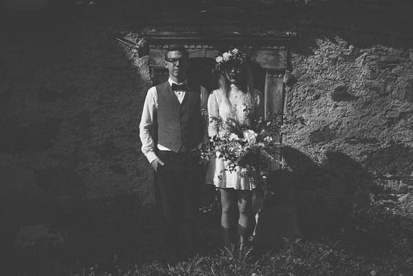 Bride and groom standing outside house