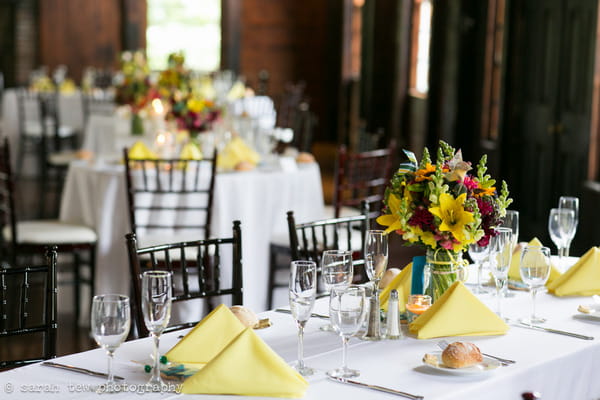 Yellow napkins and bright flowers on wedding table