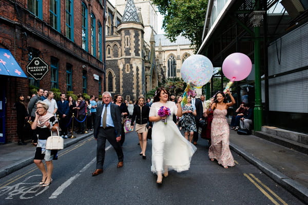 Wedding party walking through London to wedding reception at Roast