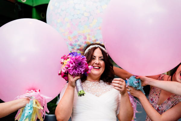 Bride surrounded by large pink balloons
