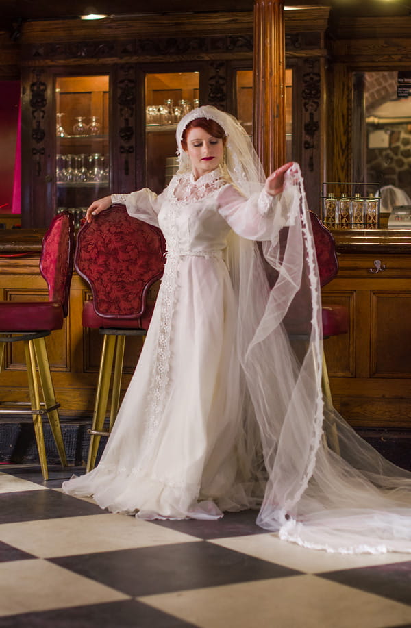 Bride wearing vintage wedding dress and long veil