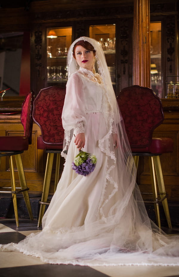 Bride wearing vintage wedding dress and long veil