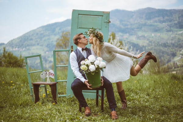 Couple about to kiss in front of rustic door in Slovenian countryside