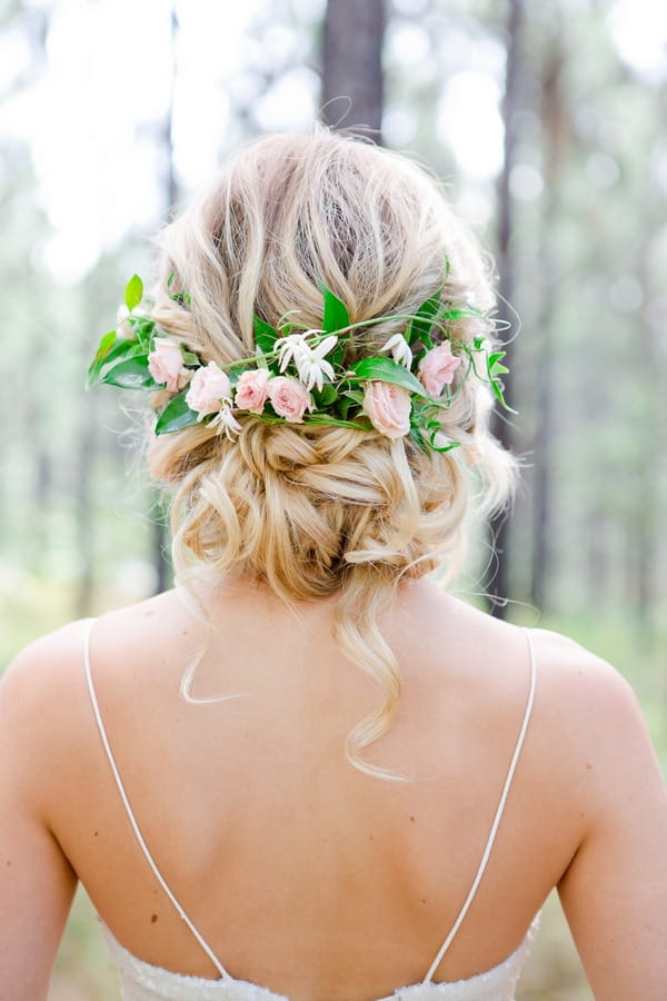 Floral hairpiece in back of bride's updo hairstyle
