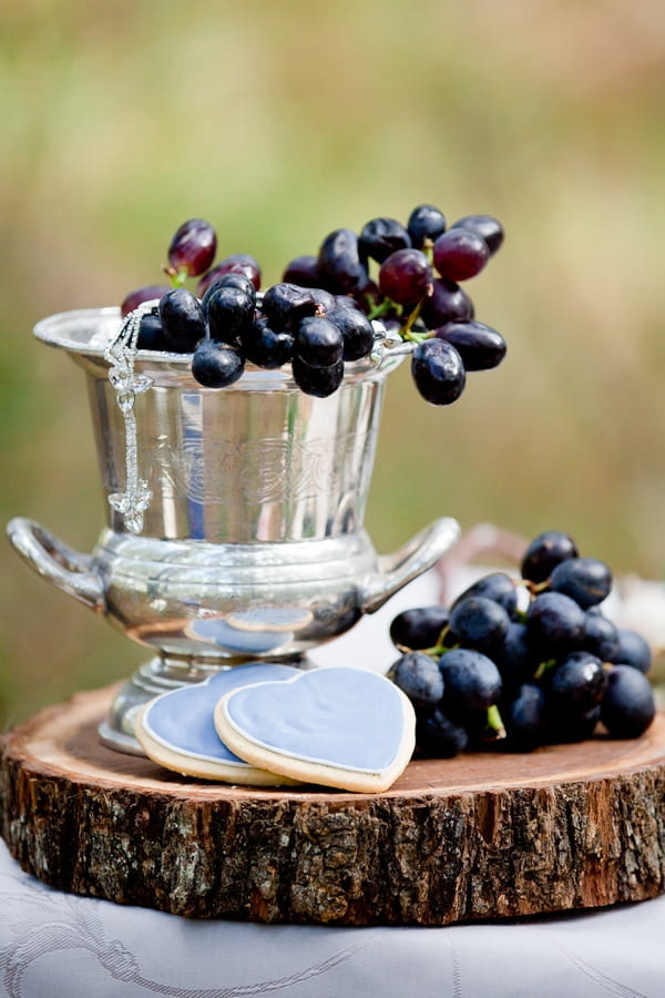 Silver bucket of grapes on log slice