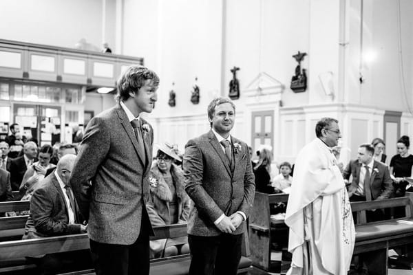 Groom and best man waiting for bride at altar