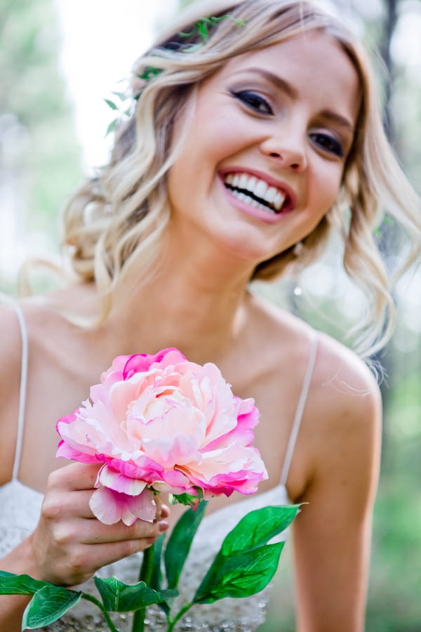 Bride holding large flower and smiling