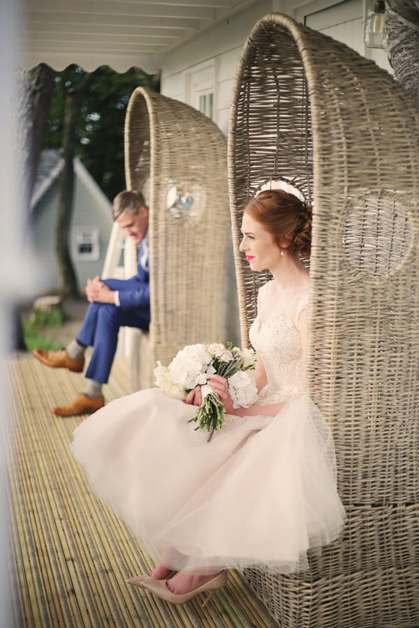 Bride and groom sitting on chairs outside house at Woodhill Hall