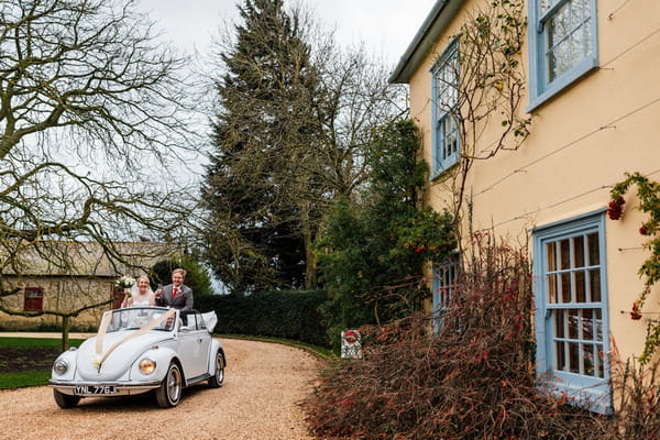 Bride and groom arriving at South Farm in convertible Beetle