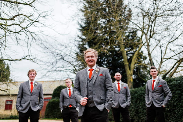 Groomsmen in tweed jackets and orange ties