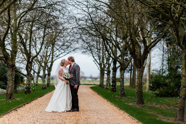 Bride and groom kissing on driveway of South Farm, Royston