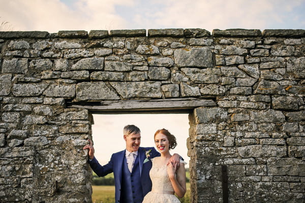 Bride and groom in front of stone wall