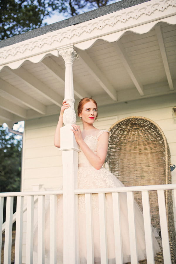 Bride leaning against pillar