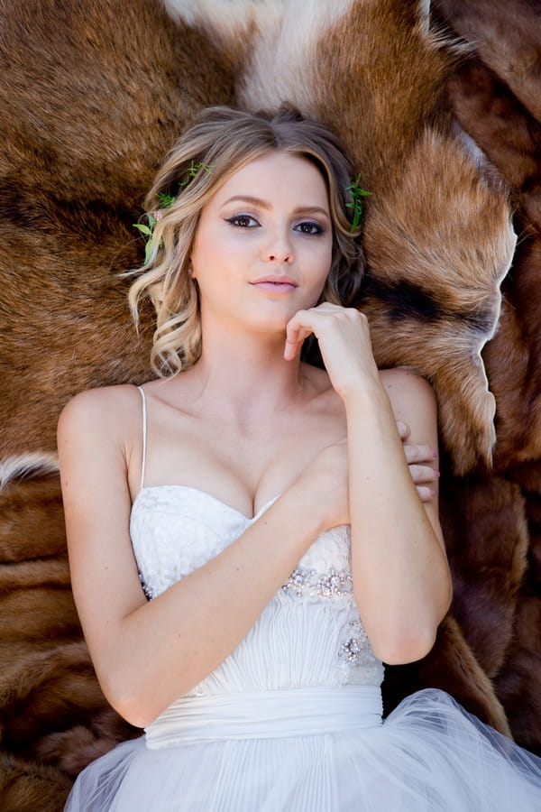 Bride laying on fur looking into camera