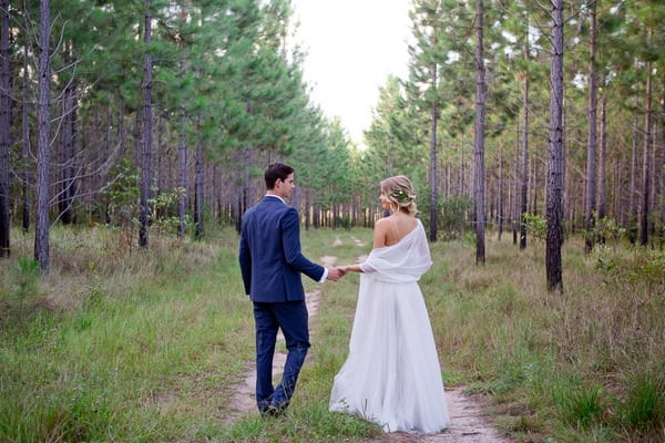 Bride and groom walking in woodland