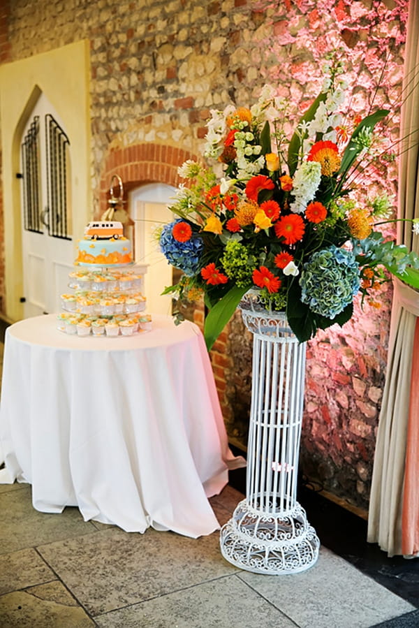Colourful wedding flowers next to cake table