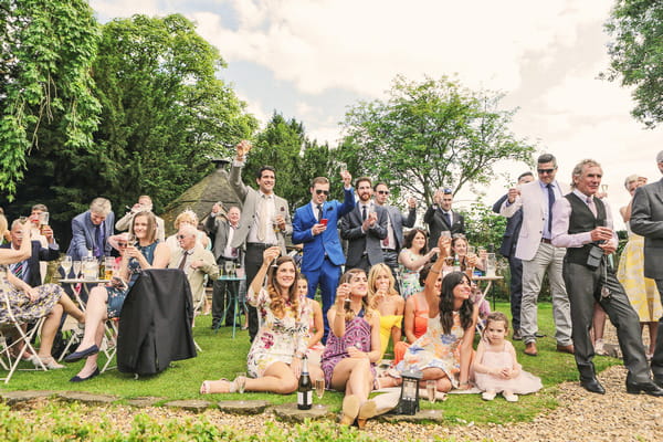 Wedding guests sitting on grass