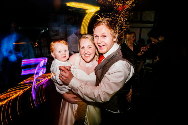 Bride and groom with son on dance floor