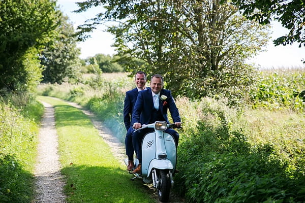 Groom and best man going to wedding on Vespa scooter