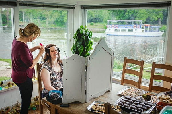 Bride looking in mirror as she has her hair done